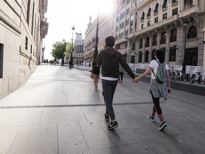 Una pareja pasea cogidos de la mano por las calles de Madrid.