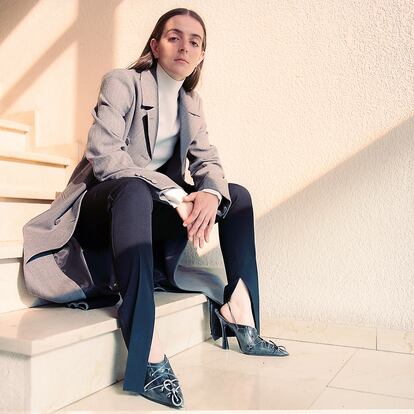 Abrigo gris, top marfil de punto y pantalón de lana, todo de GUCCI, y zapatos de ACNE STUDIOS.