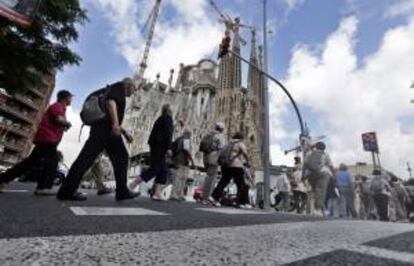 Un grupo de turistas llega caminando esta ma?ana a las inmediaciones de la baslica de la Sagrada Familia de Barcelona. EFE/Archivo