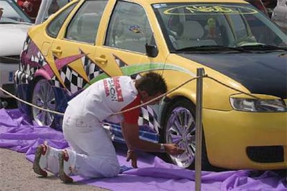 Uno de los participantes en la exhibición de <i>tuning</i> retoca la llanta de su coche.