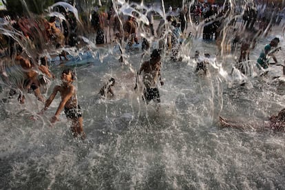 Un grupo de niños juegan y se refrescan en una fuente de un parque de Hyderabad, India, donde la temperatura ha alcanzado los 42 grados centígrados.