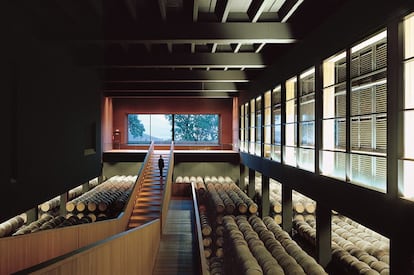 La sala de barricas de la bodega Campo Viejo, atravesada por una esbelta escalera. Enterrar parte de la bodega permitió al arquitecto conseguir de manera natural las condiciones idóneas para la elaboración y crianza del vino, aunque destaca también que "ayuda también a acercarse, con maneras actuales, a la experiencia arquitectónica de las bodegas tradicionales: espacios oscuros, serenos, muy marcados por la forma y textura de las paredes, por las escasas entradas de luz exterior".