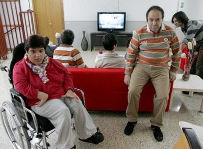 Sonia y Juan, dos internos de Atxarte, posan en la sala de televisión del centro con otros discapacitados.