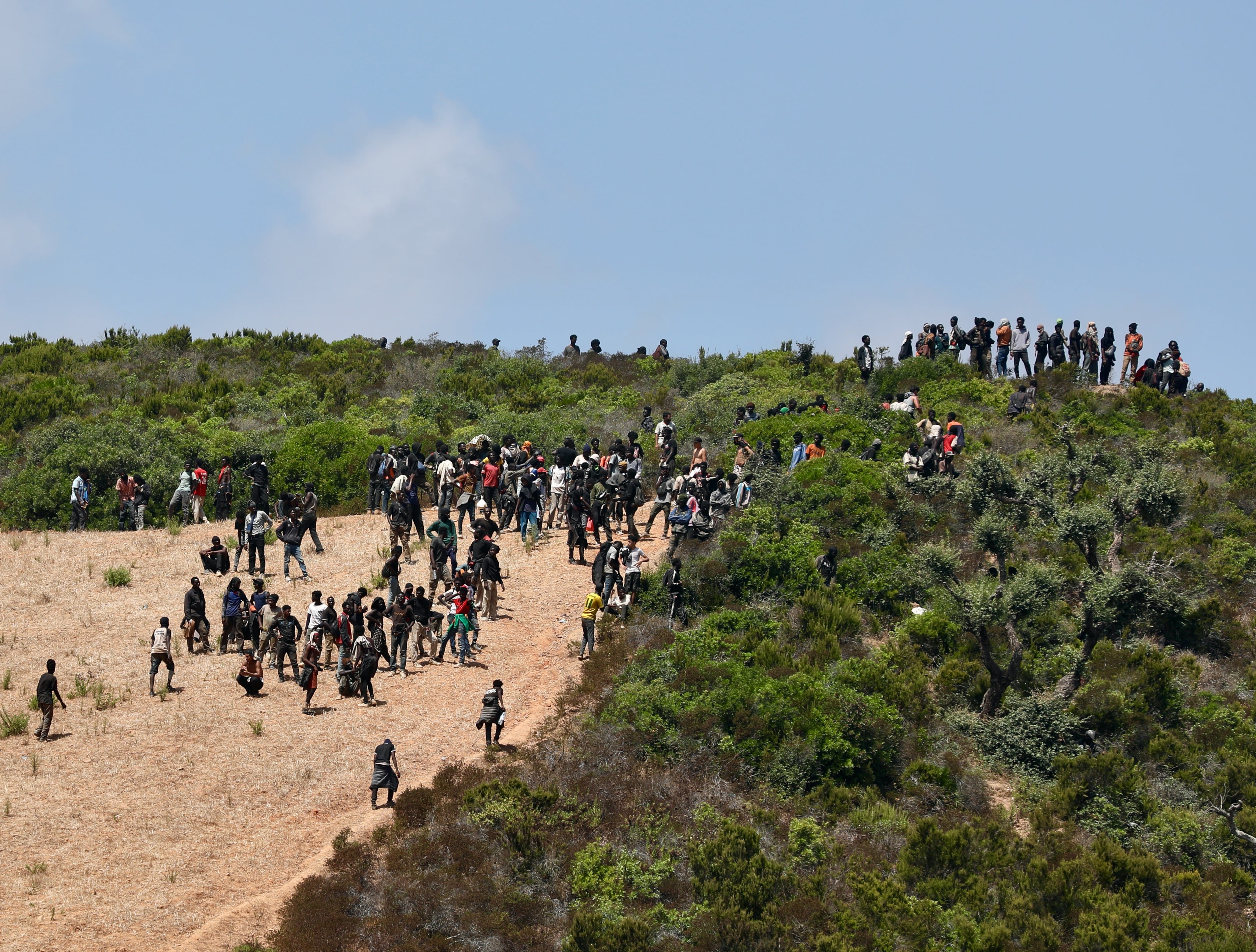 Los migrantes, la mayoría subsaharianos, se retiran a las montañas cercanas a Castillejos, tras un enfrentamiento con las fuerzas de seguridad.