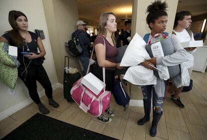 Estudiantes de la Universidad Texas A&M en Galveston Erica Tomlinson, Kourtney Gasaway y Kara Jackson esperan antes de evacuar el campus.