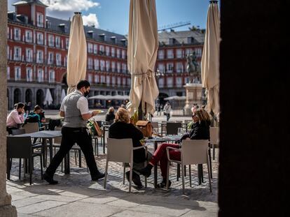 Un camarero atiende a unas clientas en la plaza Mayor de Madrid, este lunes.