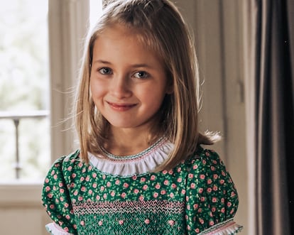 Una niña con el vestido Heritage, la estrella de la colección hecha a mano, con nido de abeja, pata de gallo, punto parís y rococó.