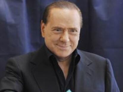 El primer ministro italiano, Silvio Berlusconi, deposita su voto en la urna de un colegio electoral en Milán