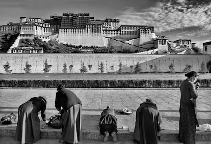 <p>Mujeres rezando y postrándose ante el Potala en Lhasa, la capital de Tíbet. El Potala era la residencia de invierno del Dalái Lama hasta que huyó a India durante el levantamiento tibetano de 1959. Ahora es un museo y es Patrimonio de la Humanidad.</p>
<p>El palacio debe su nombre al Monte Potalaka, la mítica morada de Avalokitesvara, el buda de la compasión, reencarnado en el Dalai Lama según el budismo. El 5º Dalai Lama empezó su construcción en 1645 después de que uno de sus consejeros espirituales señalase que era el lugar ideal para ser la sede del Gobierno ya que está situado entre los monasterios de Drepung y Sera y la ciudad vieja de Lhasa.El edificio mide 400 metros de este a oeste y tiene 1.000 habitaciones, 10.000 santuarios y unas 200.000 estatuas.</p>

