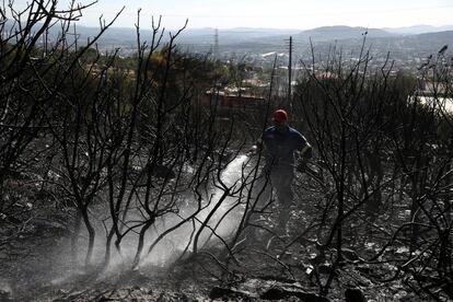 Un bombero vierte agua con una manguera durante las operaciones para extinguir un incendio forestal en el Monte Hymettus, cerca de Atenas (Grecia). El país, donde el termómetro subió hasta los 40 grados este verano, ha estado afectado en las últimas semanas por incendios forestales.