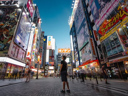Un hombre observa los carteles del barrio de Akihabara, en el centro de Tokio, Japón.