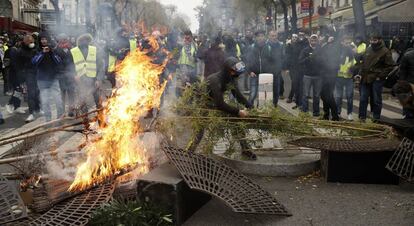 Un manifestante quema mobiliario urbano durante la protesta de este sábado en París.