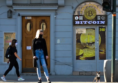 Una mujer pasea frente a una tienda de cambio de bitcoin en el centro de la ciudad de Cracovia (Polonia).