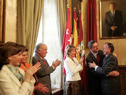 Alberto Ruiz-Gallardón abraza a José María Álvarez del Manzano ante la atenta mirada de Esperanza Aguirre.