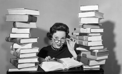 Una mujer entre dos columnas de libros.