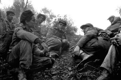 Ernesto Che Guevara, fumando una pipa, y Fidel Castro,   a su izquierda, en Sierra Maestra, en septiembre de 1957.