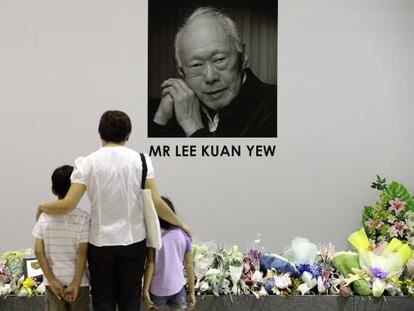 Una mujer y sus dos hijos rinden homenaje este lunes al fallecido primer ministro singapurense Lee Kuan Yew.