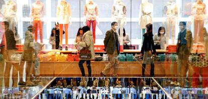 FILE PHOTO: Shoppers look at merchandise at Fast Retailing&#039;s new flagship Uniqlo store at Tokyo&#039;s Ginza district