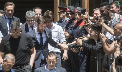 Un fan de Lionel Messi le saluda después de comparecer en el juicio.