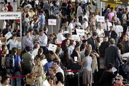 Viajeros de la operación retorno y participantes en el congreso abarrotaron ayer el aeropuerto de El Prat.