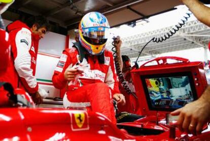 Los técnicos de Ferrari dan el último repaso al coche de Fernando Alonso en su presencia antes del Gran Premio de Brasil, el domingo.