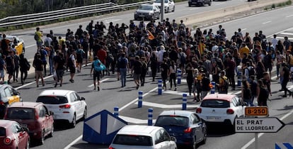 Centenares de personas se dirigen caminando por la Ronda Litoral de Barcelona al Aeropuerto de El Prat.