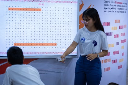 Visitantes partipan en el ejercicio de resolver la sopa de letras interactiva.