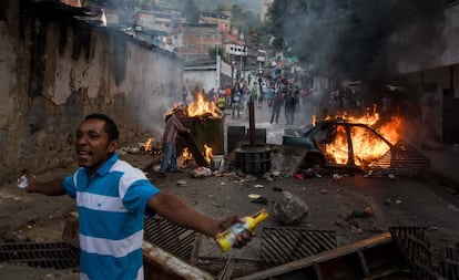 Un grupo de personas se manifiestan en una calle en las inmediaciones de un comando de la Guardia Nacional Bolivariana este lunes, en Caracas (Venezuela).