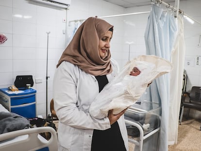 Rahma, supervisora de comadronas, sostiene a un recién nacido llamado Rivan en la maternidad de Al-Amal, en Mosul (Irak).