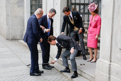 El alcalde de Madrid, José Luis Martínez-Almeida, recoge del suelo el bastón del rey emérito Juan Carlos I.
