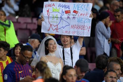 Dos aficionados, ella vestida de novia, antes del partido.