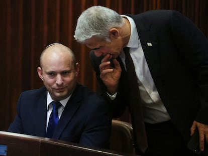 Naftali Bennett, el líder del partido Yamina (a la izquierda) escucha al jefe del partido Yesh Atid, Yair Lapid, este miércoles en la sesión especial de la Kneset.