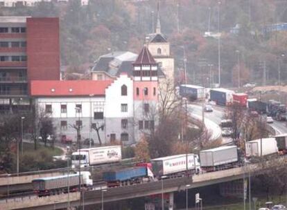 Una larga hilera de camiones transita por la variante de San Sebastián a su paso por el barrio de Amara.