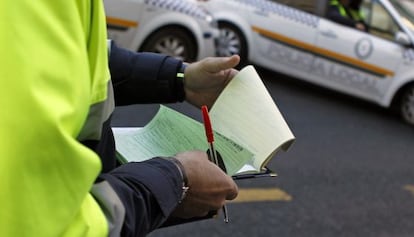 Un agente de la Polic&iacute;a Local de Sevilla rellena el papeleo de una multa.