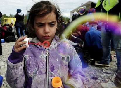 Una niña hace una poma de jabón en un campo de tránsito para inmigrantes en Gevgelija (Macedonia).