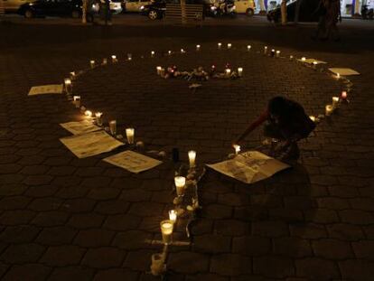 Una chica enciende unas velas en memoria de los normalistas de Ayotzinapa.