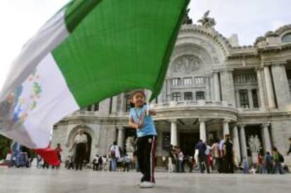 Una niña ondea una bandera mexicana frente al Palacio de Bellas Artes. La economía mexicana aumentó un 4,3 % en el primer semestre de 2012 respecto al mismo período del año anterior, aunque se prevé una ligera desaceleración en la segunda mitad del año para cerrar en torno al 4 por ciento. EFE/Archivo