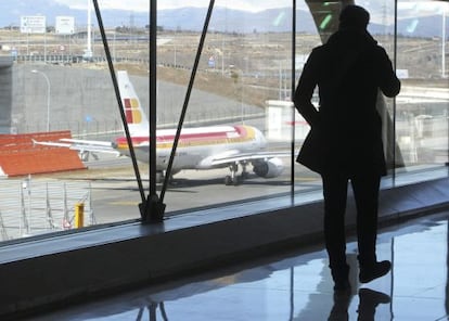 Un pasajero observa un avi&oacute;n de Iberia en el aeropuerto de Madrid-Barajas