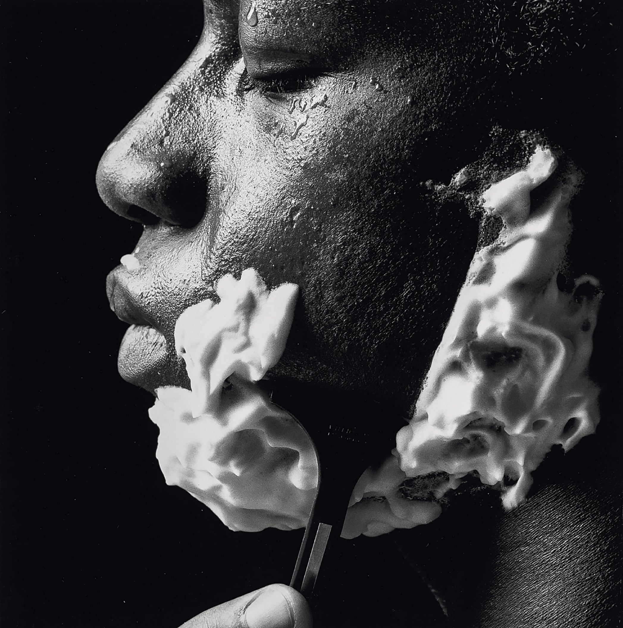 Un hombre negro usa espumas especiales para afeitarse.