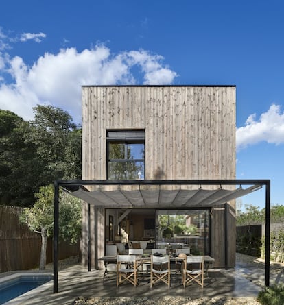 Esta casa cercana a Barcelona se montó en 15 días. En cinco meses estaba amueblada y había florecido el jardín. La consigna fue obtener lo máximo con lo mínimo. En la imagen, la madera del exterior está barnizada en mate. Las sillas menorquinas son de Anglada, y la mesa de teca, de Vinçon.