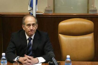 Ehud Olmert, primer ministro en funciones, sentado junto a la silla de Ariel Sharon en el Consejo de Ministros celebrado ayer en Jerusalén.