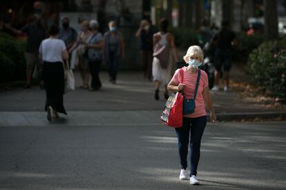 Una mujer camina por el paseo Sant Joan de Barcelona el primer día en el que las mascarillas son obligatorias.