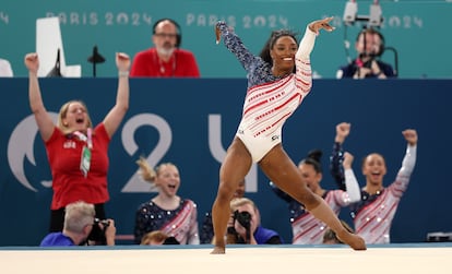 Simone Biles, de Estados Unidos, durante su ejercicio en suelo mientras su equipo celebra.
