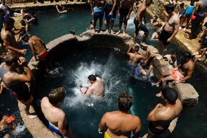 Un grupo de palestinos se refrescan en una fuente natural en la ciudad cisjordana de Jericó, en el Eid al Fitr, la festividad que marca el fin del mes sagrado musulmán de Ramadán.