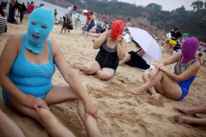 Varias bañistas protegen el rostro de los rayos uva con la llamativa máscara, que sorprende a más de un visitante a las playas chinas.