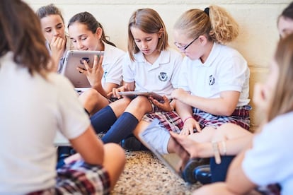 Un grupo de ni&ntilde;os lee en sus tabletas y libros electr&oacute;nicos. 