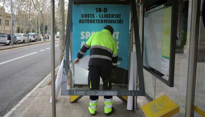 Un operario retira uno de los carteles de Tsunami Democràtic 