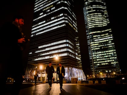 Varias personas pasean por la zona de las cuatro torres en Madrid.