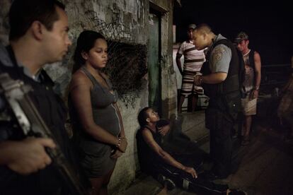 El soldado de la UPP Octavio Sardiña interroga a un sospechoso de violación. Rossane, la mujer que llamó a la policía, identifica al agresor mientras algunos vecinos son testigos de la escena en la favela de Vidigal en Río de Janeiro. Brasil, 18 de febrero de 2012.