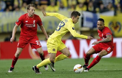 El centrocampista del Villarreal, Denis Suárez (c), controla la pelota ante los jugadores del Liverpool, Lucas Leiva (i), y Nathaniel Clyne (d).